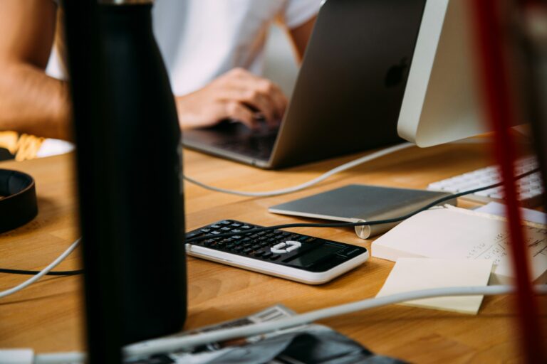 Personne vérifiant ses abonnements inutiles avec un ordinateur et une calculatrice