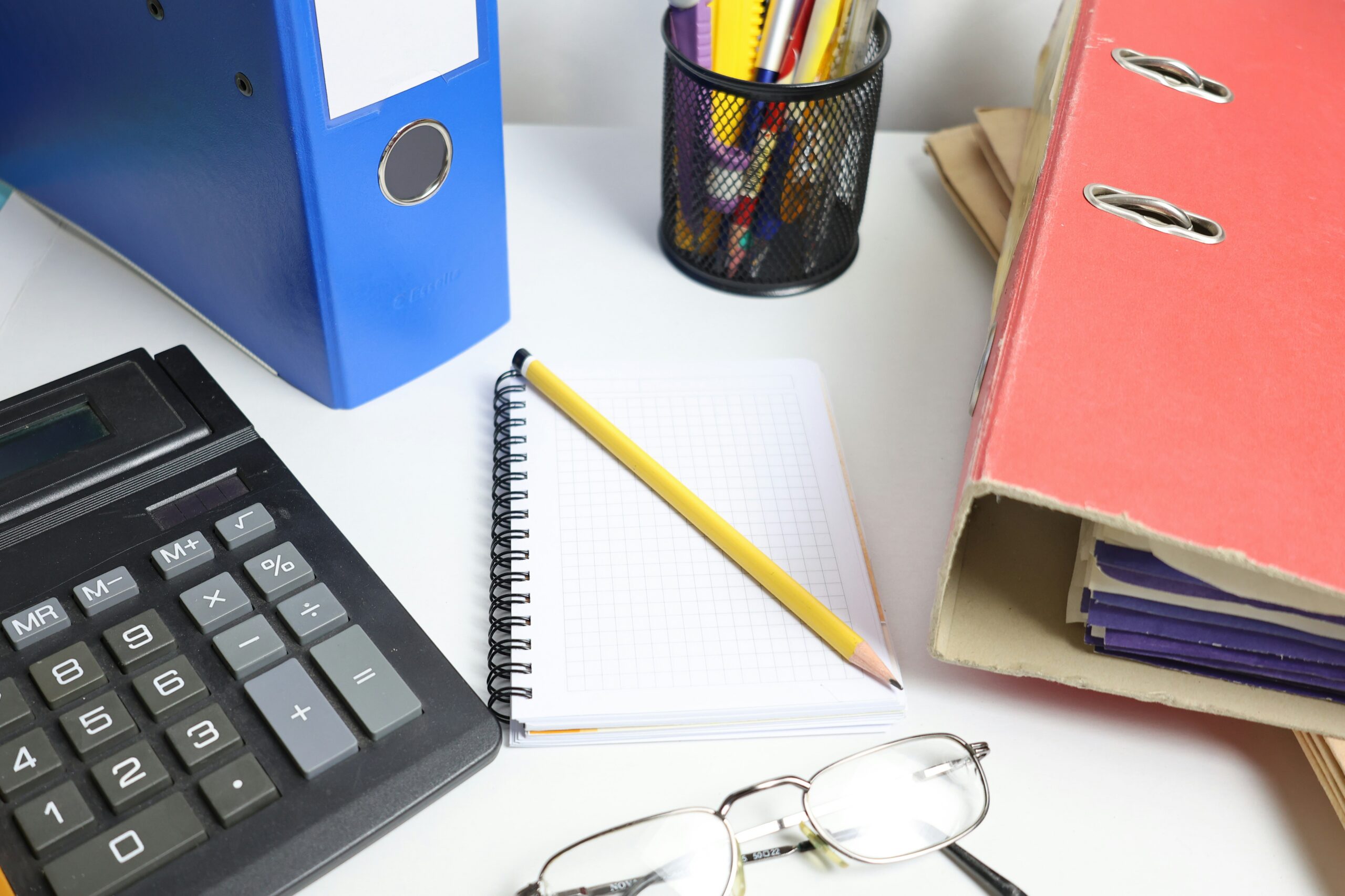 Documents, factures et classeurs organisés sur un bureau avec un ordinateur