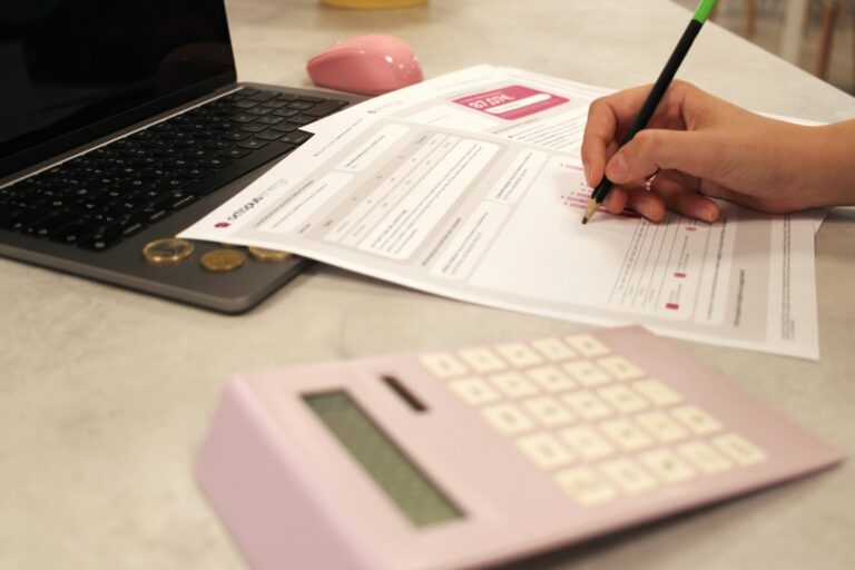 Personne analysant ses dépenses fixes avec un ordinateur et une calculatrice