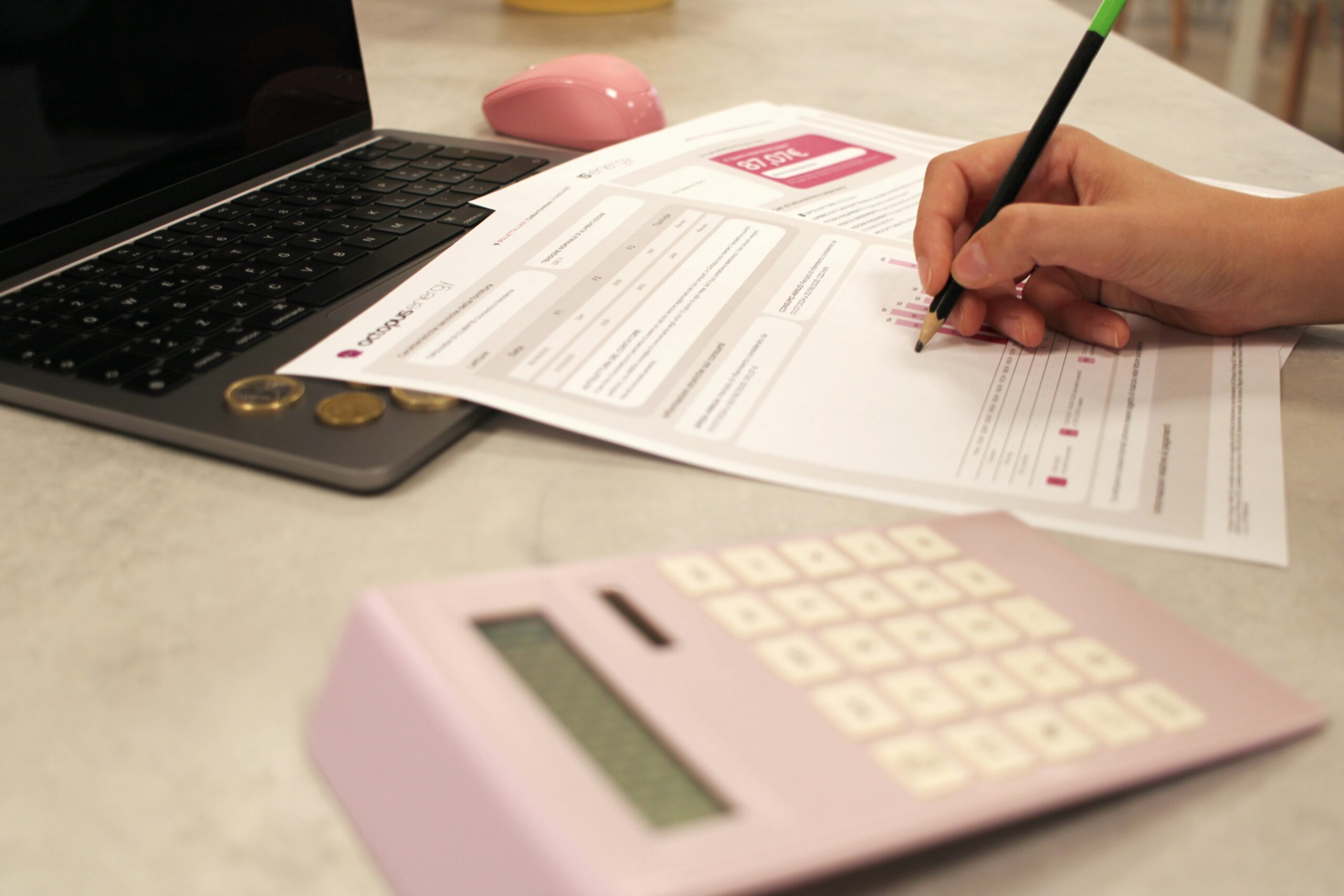 Personne analysant ses dépenses fixes avec un ordinateur et une calculatrice