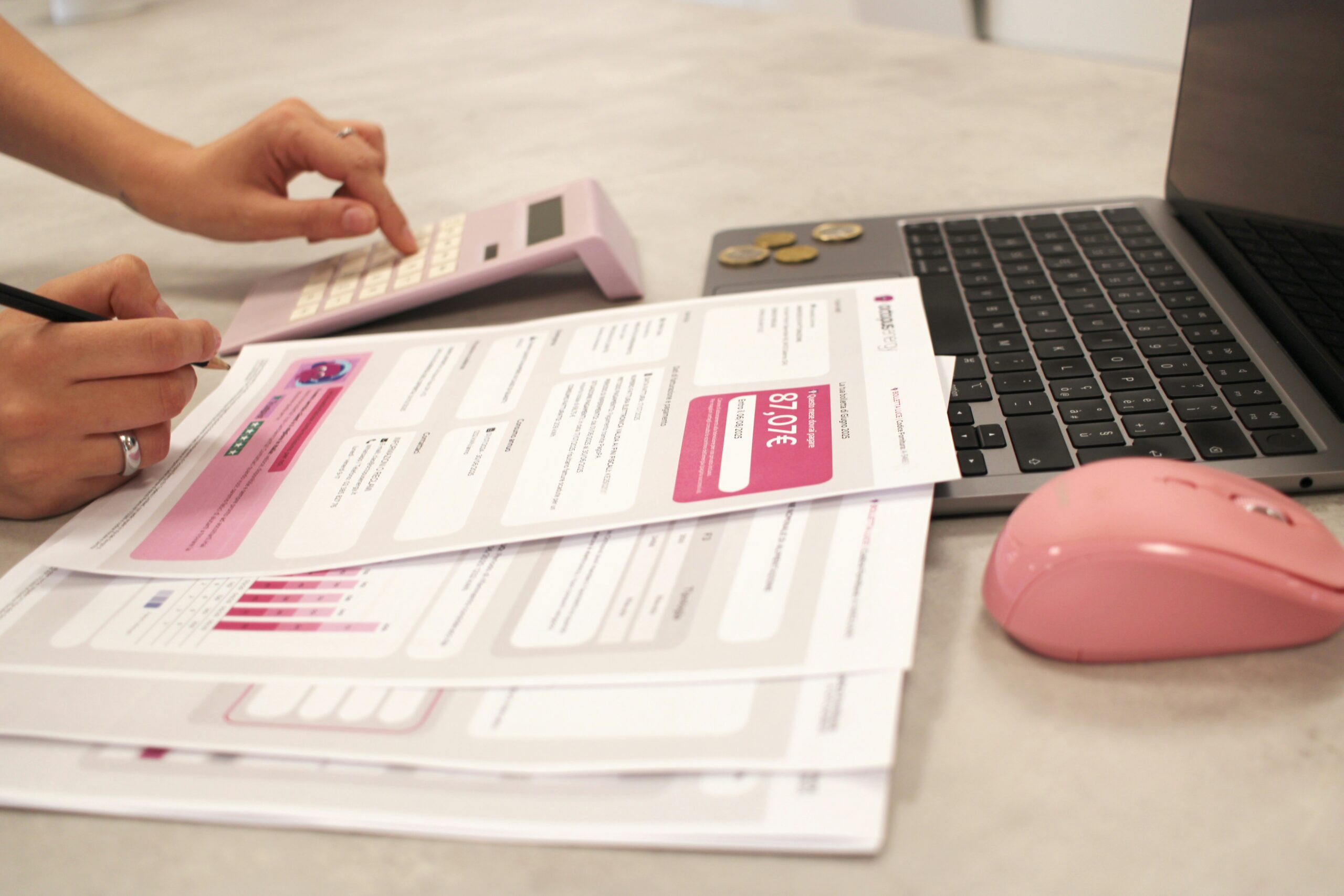 Personne comparant plusieurs offres de contrat avec un ordinateur, des documents et une calculatrice