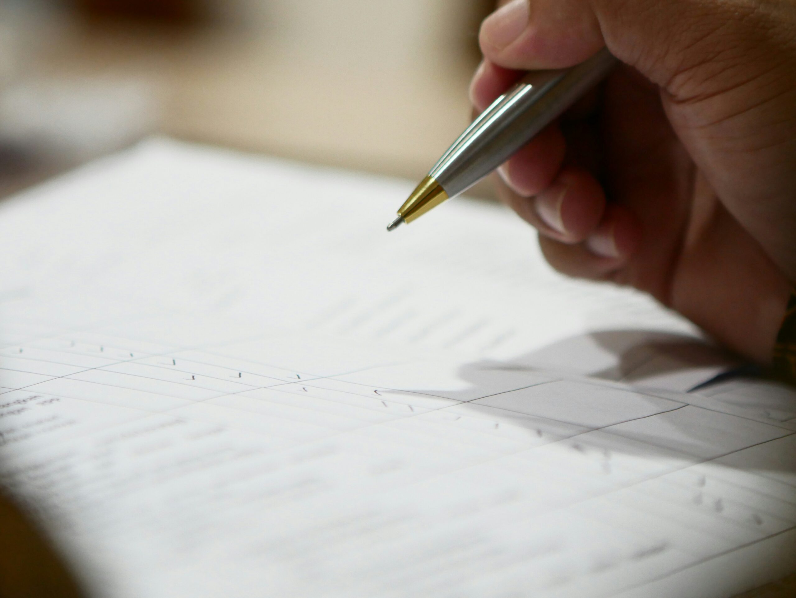 Personne lisant attentivement les petites lignes d’un contrat avec un stylo