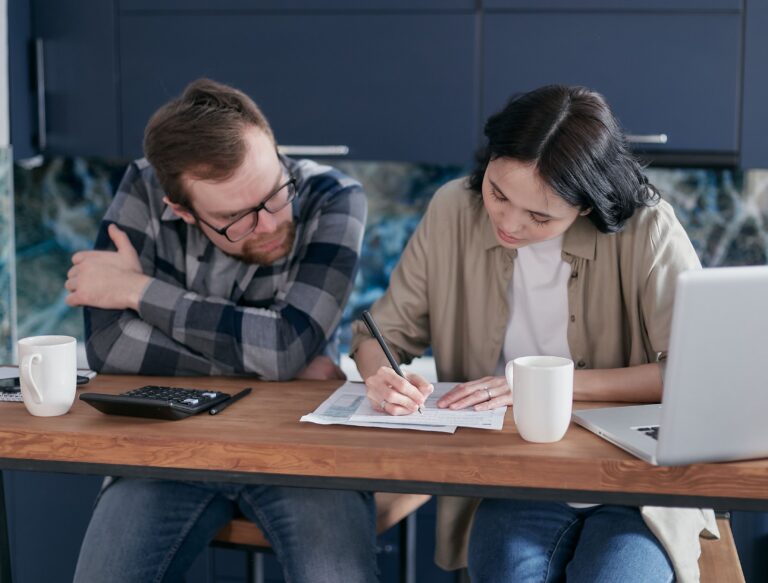 Contrats d’assurance auto, habitation et emprunteur avec calculatrice et carnet de budget sur une table familiale